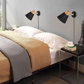 Modern bedroom with a bed, nightstands, and wall sconces.